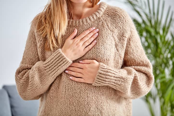 Person holding their chest in pain