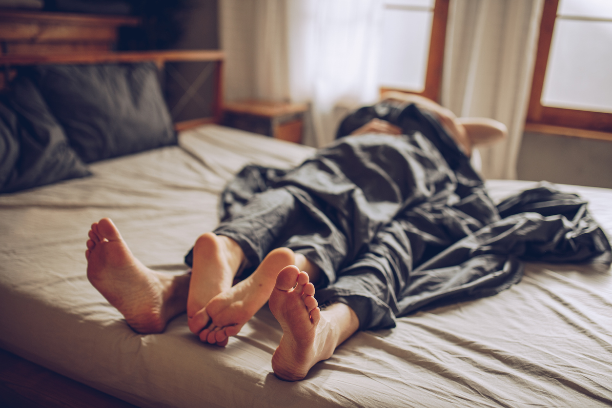 Couple under sheets in a bedroom