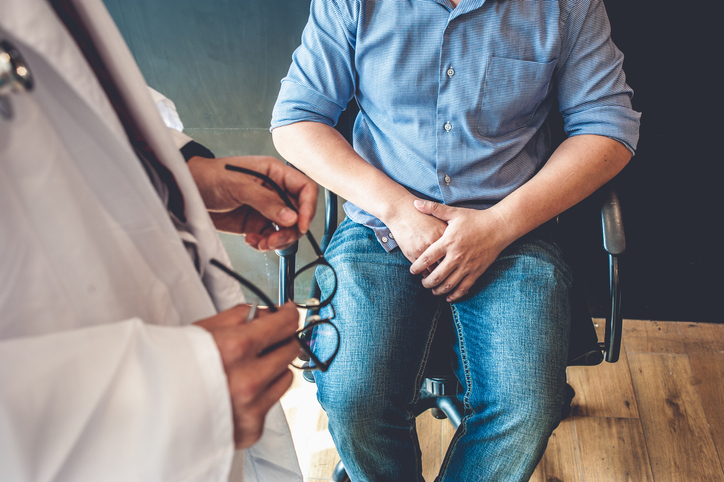 Doctor talks with a man, sexual health concept 