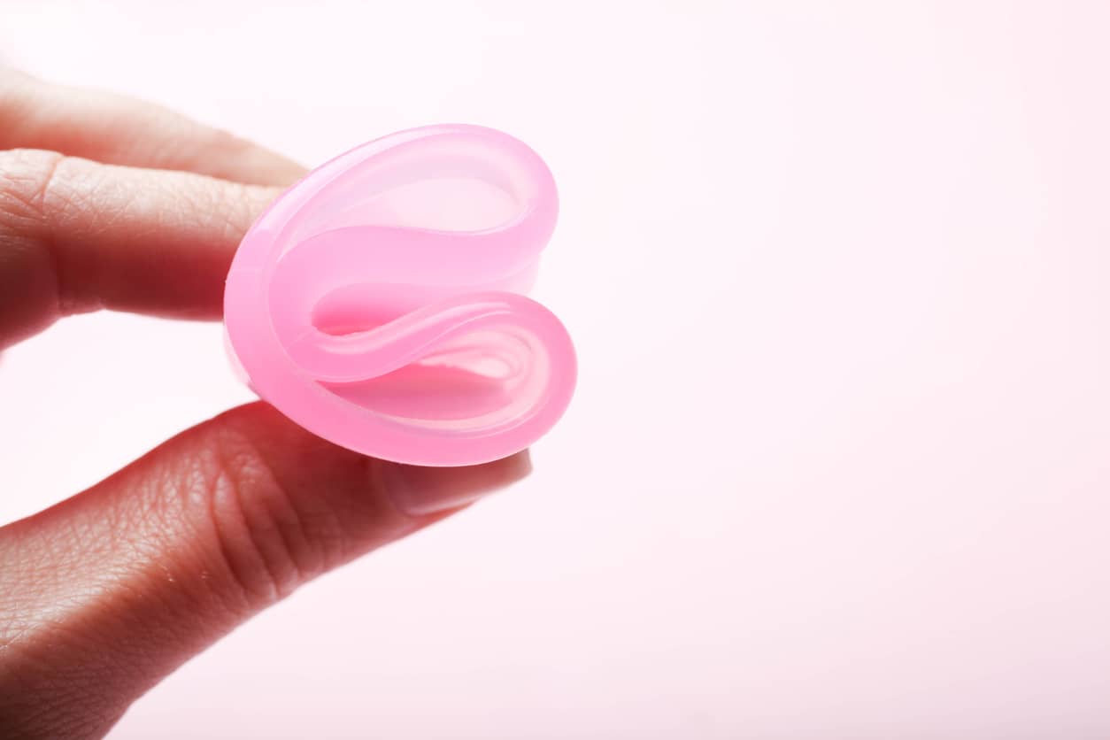 Hand holding folded menstrual cup moon cup