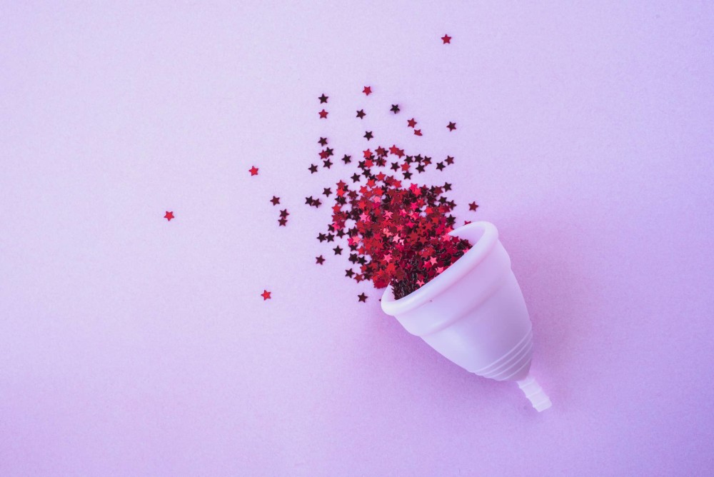 Red glitter stars falling out of menstrual cup