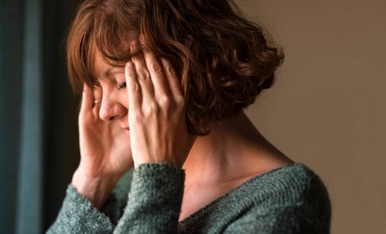 Person holding their temples suffering with a cluster headache
