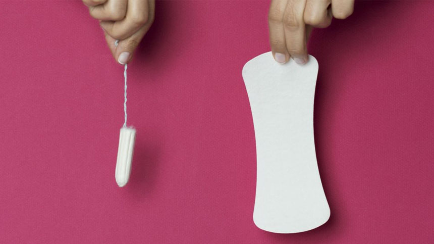 Person holding a tampon and a sanitary towel