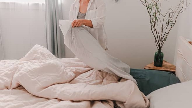 Person changing their bed linen