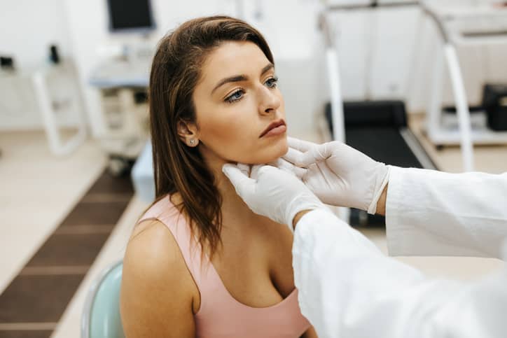 Doctor checking a woman's neck
