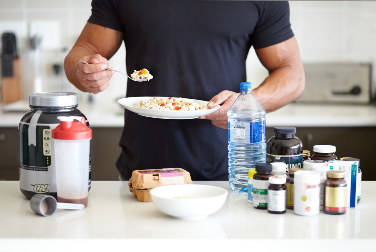 man-surrounded-by-nutrition-supplements
