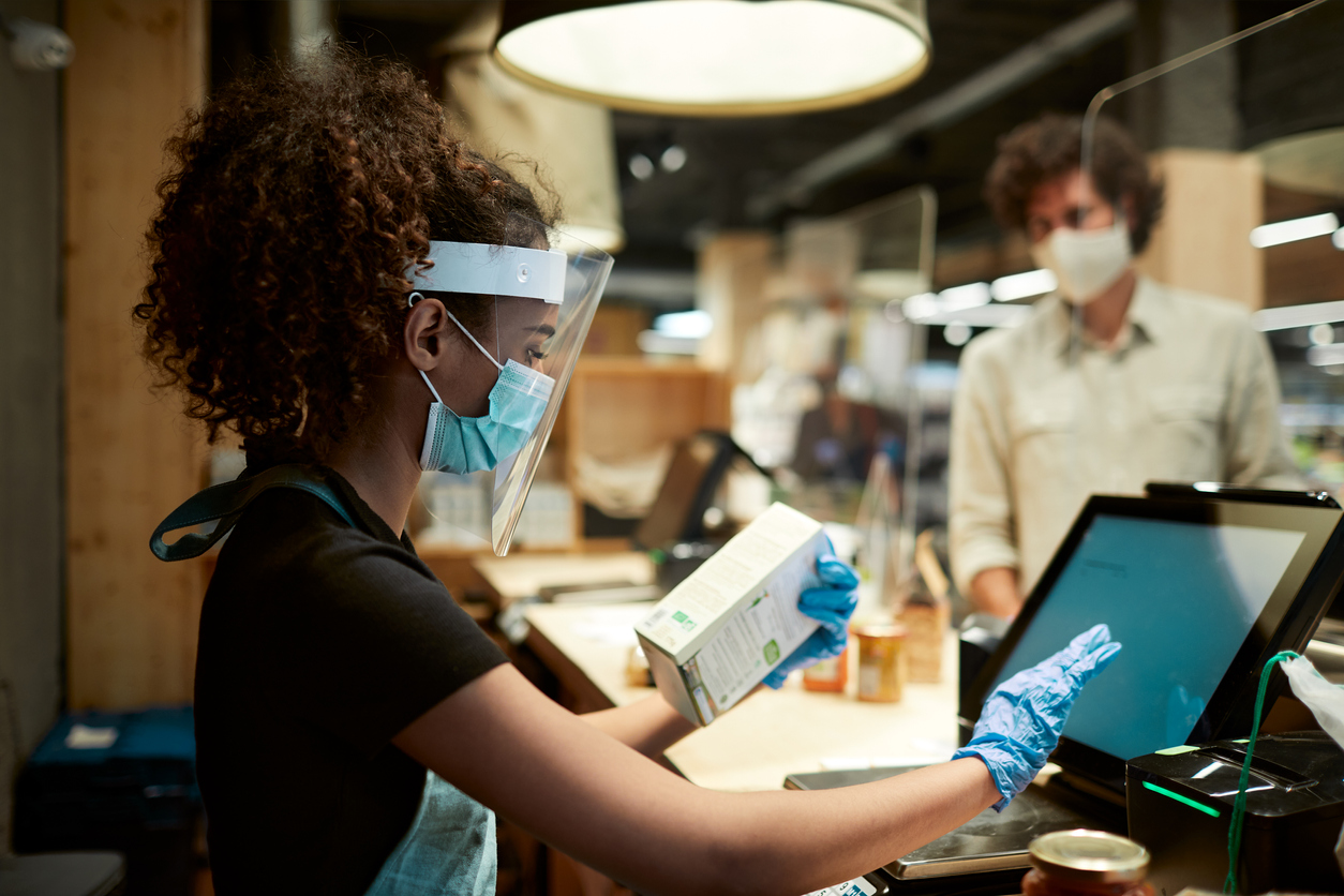 Man wearing a mask while being served in a shop during coronavirus pandemic