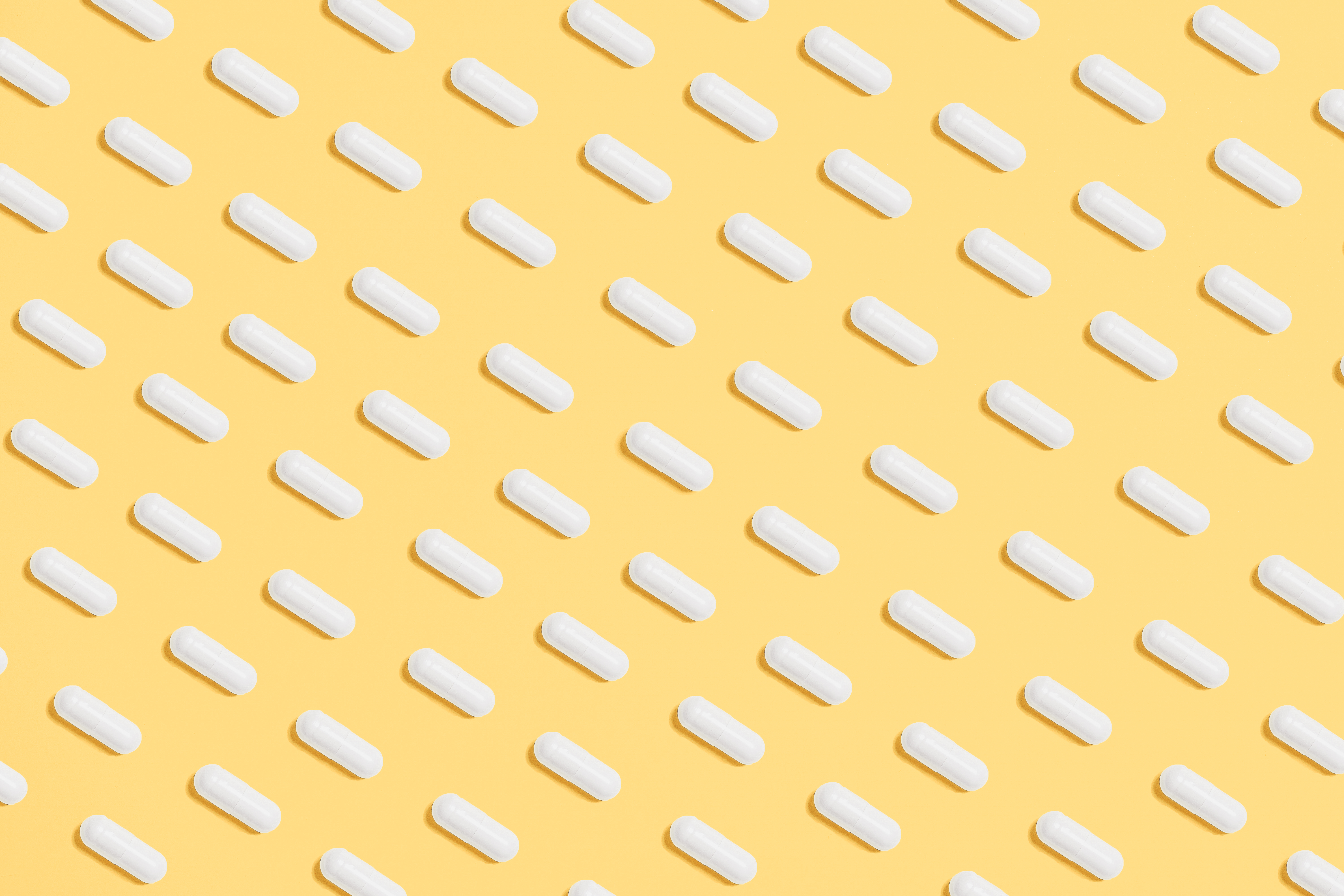 White Capsules on Yellow Background