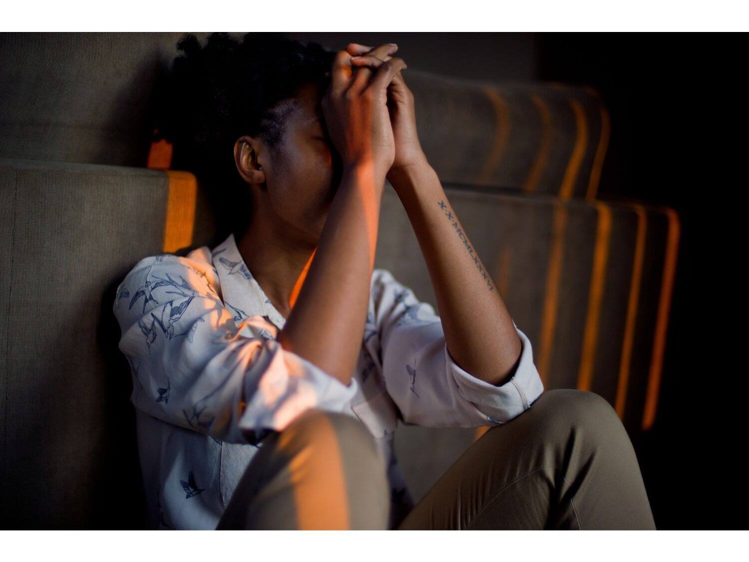 A woman sitting against a sofa
