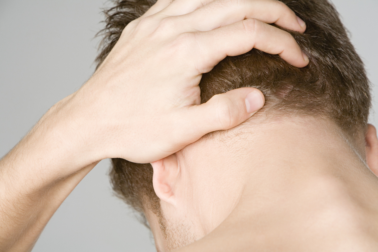Up close back view of man with left hand on head (credit - image source)