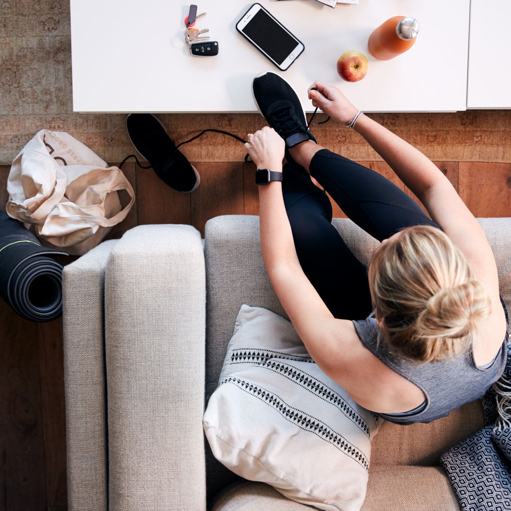 woman-putting-on-trainers-before-home-workout