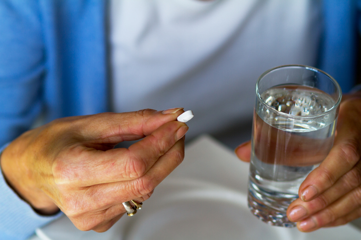Woman holding a tablet and glass of water 