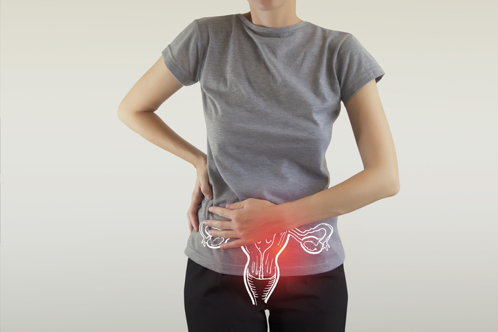 Woman in grey t-shirt, focus on human reproduction system 