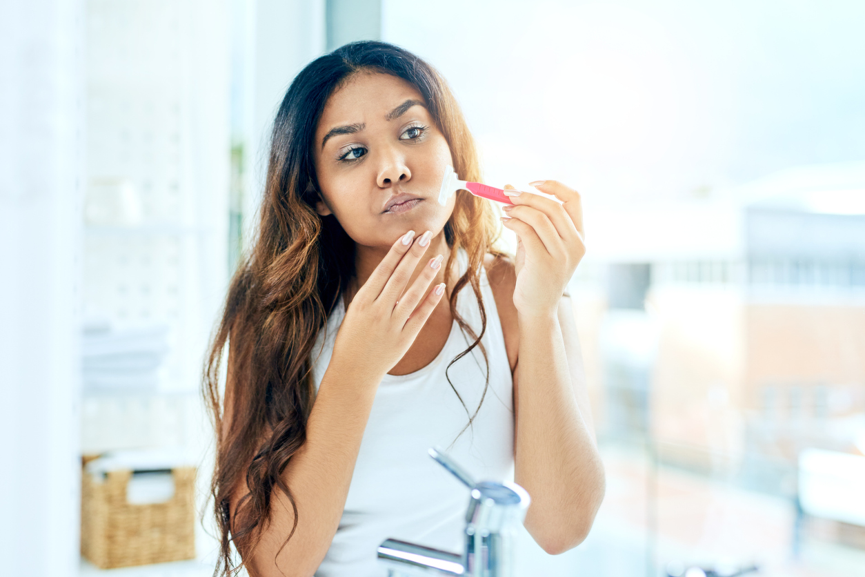 Woman shaving her face