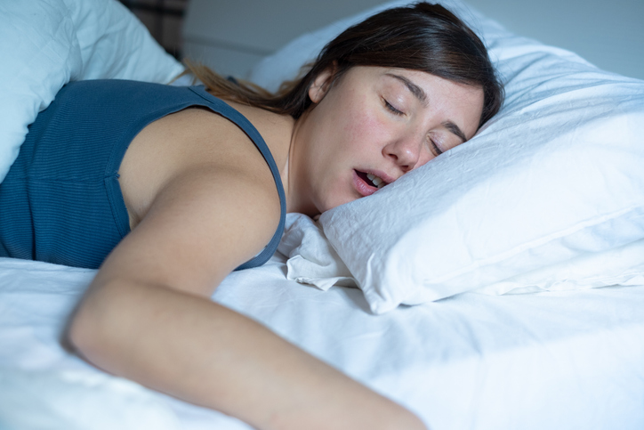 Woman with sleep apnoea snoring in bed