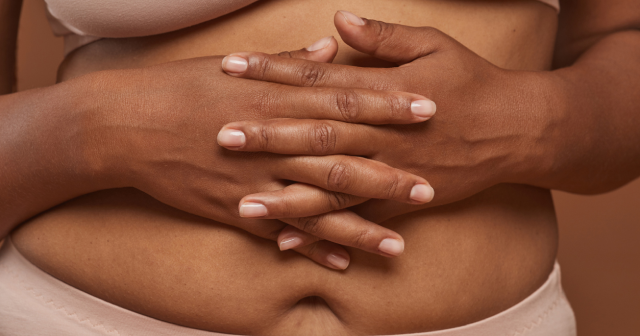 Bloated woman holding stomach